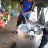 A volunteer cooks in the refugee's tent kitchen - Ternate