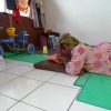 A woman rests on the floor of a refugee center - Ternate