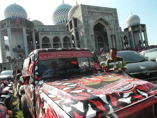A proto-military jeep in front of a mosque at a Partai Aceh rally in Aceh, Indonesia