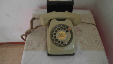 Ancient rotary phone under lock and key